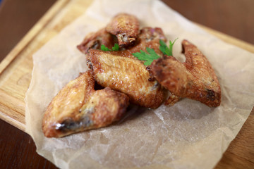 Fried chicken wings on wooden board