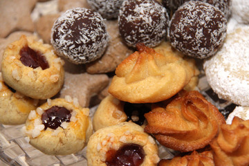 Various christmas biscuits lie on a glass plate