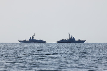 Obraz premium Warships moving in sea in the opposite directions. Two navy ships on the horizon.