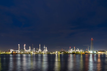 Fototapeta na wymiar Oil refinery at night petrochemical and energy industry with refection on river