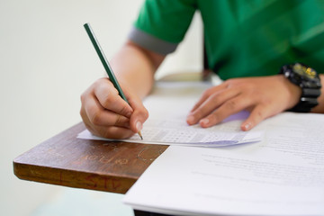 Student check Answer choice with pencil on optical form of standardized test answers bubbled score and a black paint examination box,Answer sheet School,education in university concept