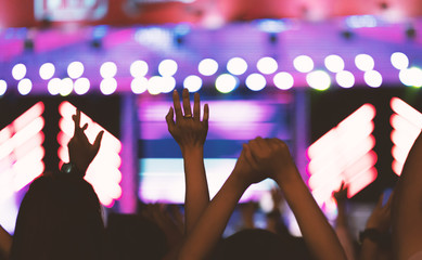 Hand crowd at concert - Cheering crowd in front of bright colorful stage lights ,vintage color