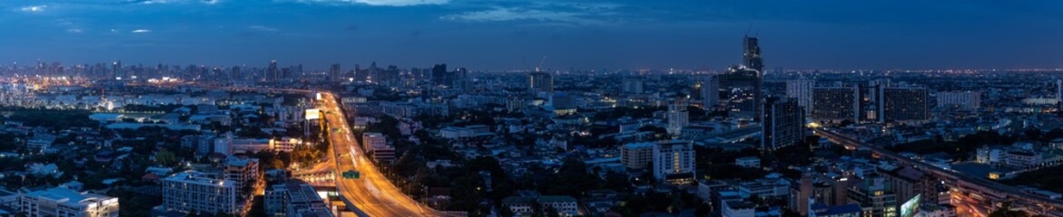 Fototapeta na wymiar Expressway arial view and city center skyline panorama during night with light trail, Bang Na, Bangkok Thailand