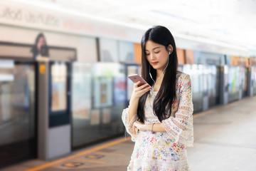 digital travel concept. young Asian woman traveling by the train or Mass Rapid Transit(MRT) train...