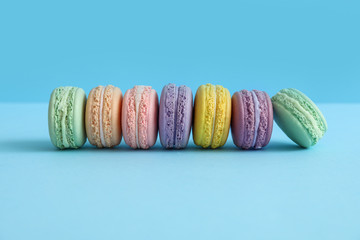 Tasty macarons on color background