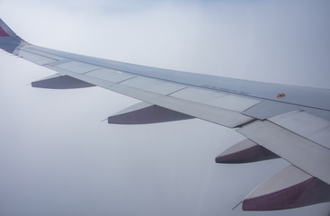 An airplane window view of wing and flaps 