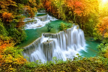 Fotobehang Kleurrijke majestueuze waterval in nationaal parkbos in de herfst - Image © wirojsid