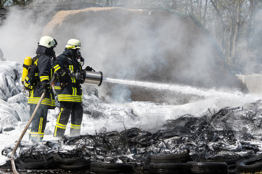 Feuerwehr löscht mit Wasser und Schaum brennende Reifen