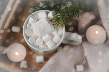 Fototapeta na wymiar 1 Cup hot chocolate cocoa with marshmallows, fir branch, candles, lights, bokeh