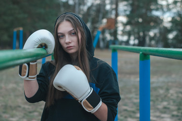 Boxer girl outdoors. The concept of a strong girl,