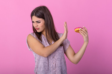 Woman on dieting for good health concept. Close up female using hand push out her favourite donut for good health. Diet, dieting concept. Junk food, Slimming, weight loss