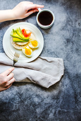 Top view Of Young Woman Having A Lunch Break. Rice crispy cakes with avocado and fresh salted salmon. Male hands with food rich in fat and protein. Space for text