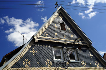 Wohnhaus mit Schiefer verkleidet und hellen Ornamenten an der Fassade