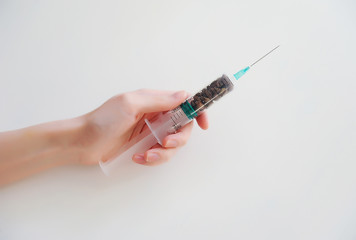 Coffee beans in a medical syringe in the hand. Caffeine addiction symbol. Medical and healthcare concept