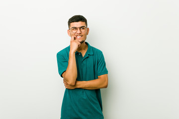 Young hispanic man biting fingernails, nervous and very anxious.