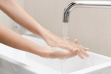 Women open faucets in the bathroom to wash hands, remove dirt and bacteria.
