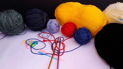 group of colorful yarn balls with crocheting accessories .close