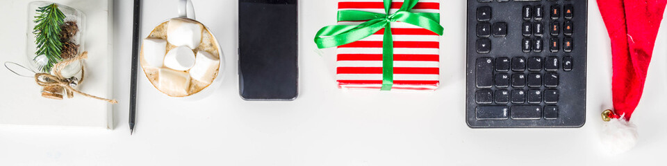 Office secret santa concept with Office table surface, keyboard, mouse, gift boxes and Christmas decoration white background copy space