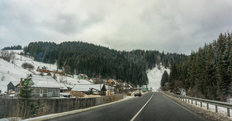 Winter rural landscape in the Carpathian mountains, Ukraine. Highway and snowy mountainsides