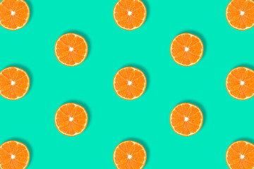 Fruit pattern of fresh mandarin slices on blue background.
