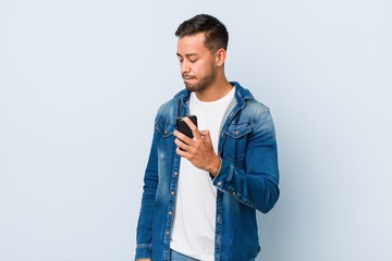 Young south-asian man holding a phone