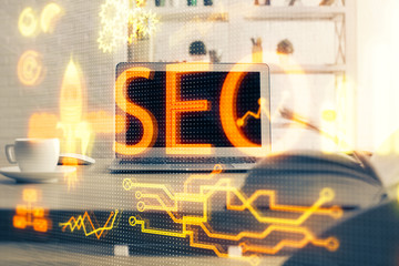 Multi exposure of table with computer and seo drawing hologram. Search optimization concept.