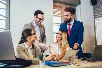 Business colleagues working on laptop in modern office.