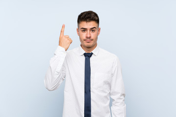 Handsome businessman over isolated blue background pointing with the index finger a great idea