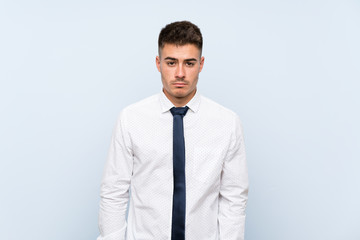 Handsome businessman over isolated blue background sad