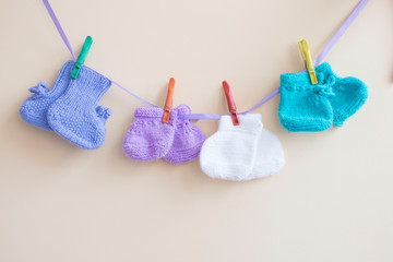 baby colorful socks hanging on a rope on clothespins on a light background