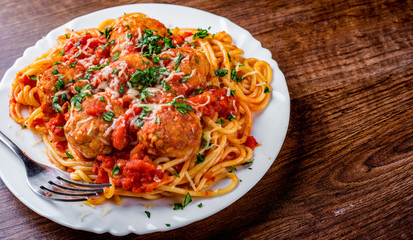 pasta spaghetti with meatballs in tomato sauce on a plate on wooden table background