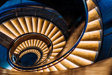 Top view of a spiral staircase lit with yellow light