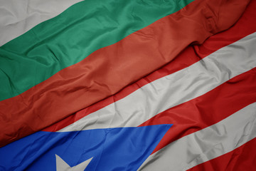 waving colorful flag of puerto rico and national flag of bulgaria.