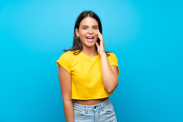 Young girl over isolated blue background with surprise and shocked facial expression