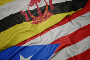 waving colorful flag of puerto rico and national flag of brunei.