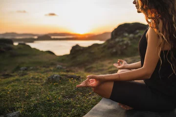  Healthy Lifestyle and Yoga Concept. Close-up hands. Woman do yoga outdoors at sunrise in lotus position. Woman exercising and meditating in morning. Nature background. © Oleg Breslavtsev