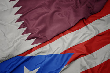 waving colorful flag of puerto rico and national flag of qatar.
