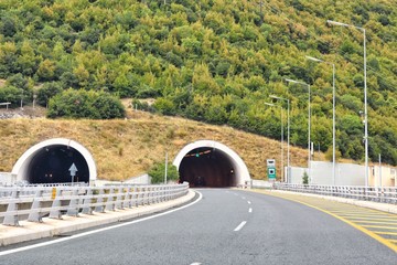 Road tunnel in mountains. Mountain road tunnel with luminous safety lights and yellow road line....