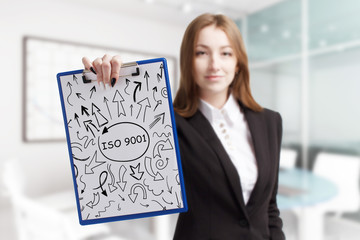 Business, technology, internet and network concept. Young businessman shows a keyword: ISO 9001