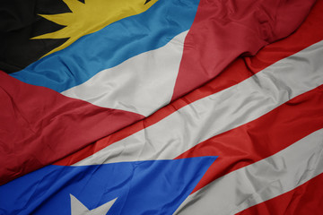 waving colorful flag of puerto rico and national flag of antigua and barbuda.