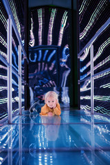 Little toddler boy in a space ship, illuminated in different colors