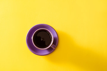 Purple cup of coffee on the yellow background