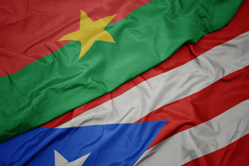 waving colorful flag of puerto rico and national flag of burkina faso.