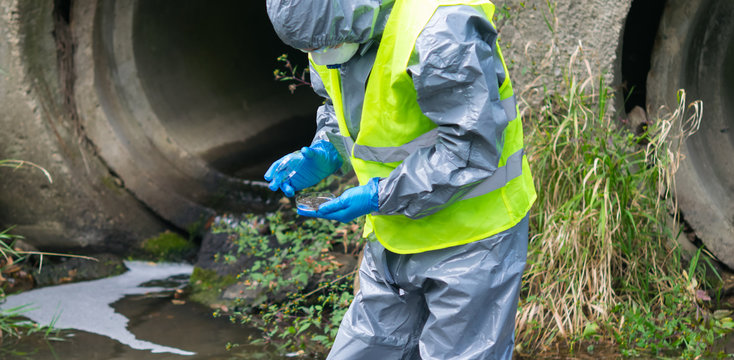 scientist in a protective suit and mask, collects mold treatment facilities to study the parameters of water in a Petri dish