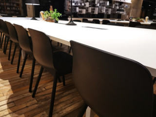 Black chairs arranged beside the white tables in the building