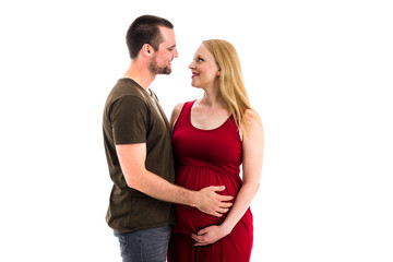 Naklejka premium Young pregnant couple in love expecting child, studio portrait.