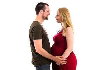 Young pregnant couple in love expecting child, studio portrait.