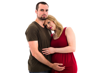 Young pregnant couple in love expecting child, studio portrait.