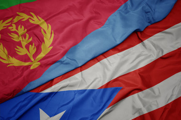 waving colorful flag of puerto rico and national flag of eritrea.