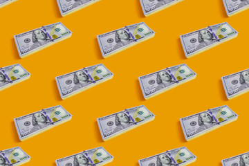 Pattern of stack of hundred dollars on yellow background
